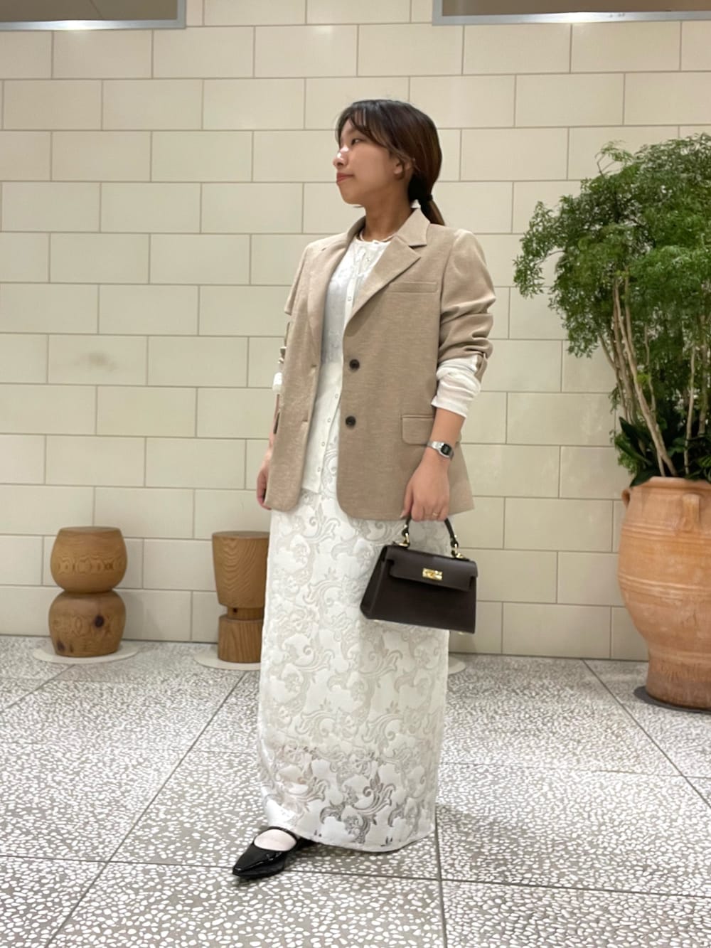 ベージュ系のその他アウター、ホワイト系のその他トップス、ホワイト系のスカートを着用したレディースの春コーディネートの2枚目の写真