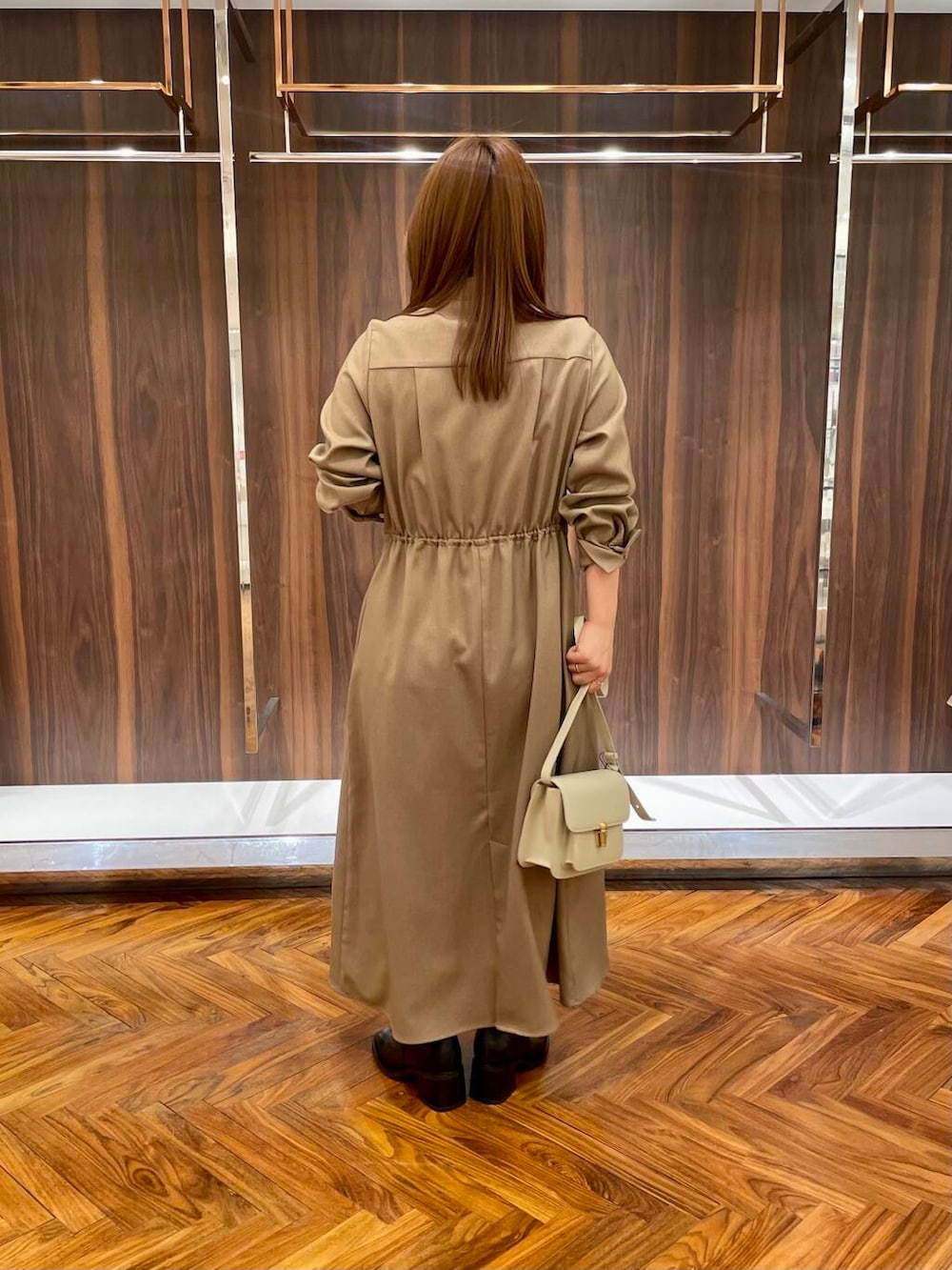 ブラウン系のワンピース、ブラック系のブーツ、ベージュ系のショルダーバッグを着用したレディースの秋コーディネートの4枚目の写真