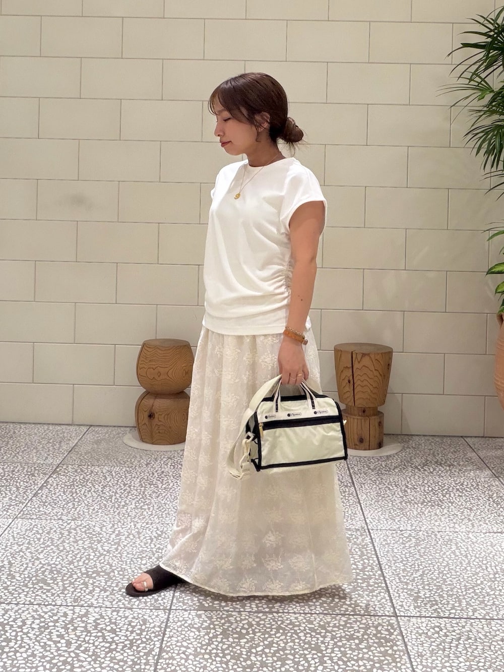 ホワイト系のTシャツ/カットソー、ベージュ系のショルダーバッグ、ホワイト系のスカートを着用したレディースの夏コーディネートの2枚目の写真