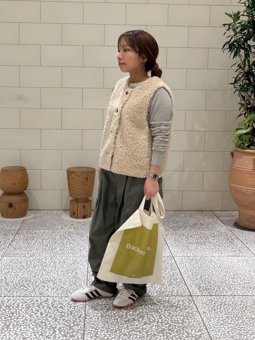 ベージュ系のダウンベスト、ホワイト系のTシャツ/カットソー、グリーン系のその他パンツを着用したレディースの秋コーディネートの3枚目の写真