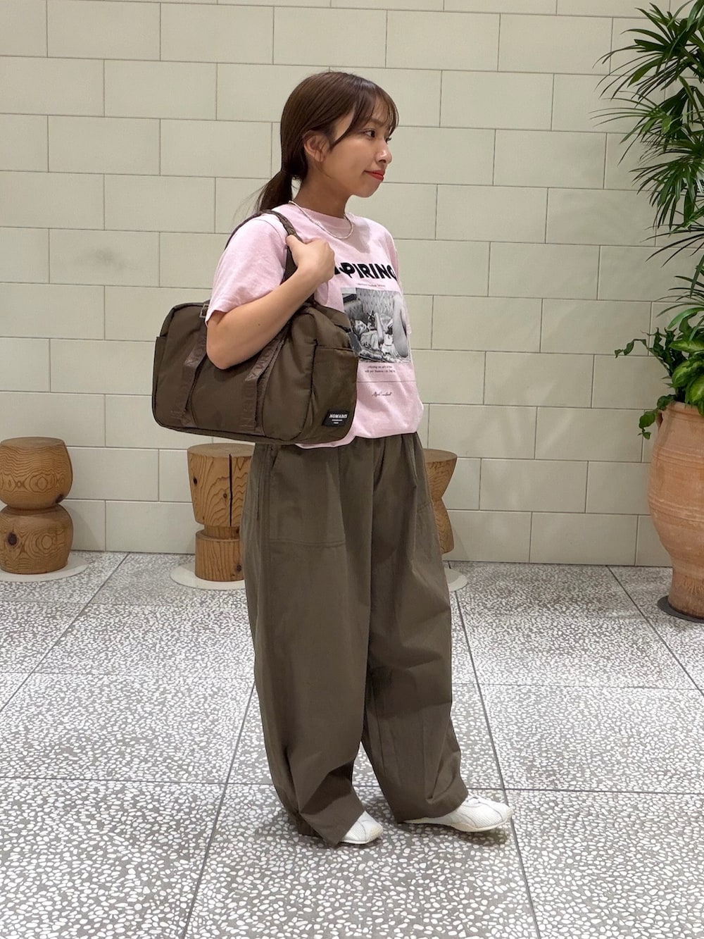 ピンク系のTシャツ/カットソー、グリーン系のその他パンツ、ブラウン系のボストンバッグを着用したレディースの夏コーディネートの3枚目の写真