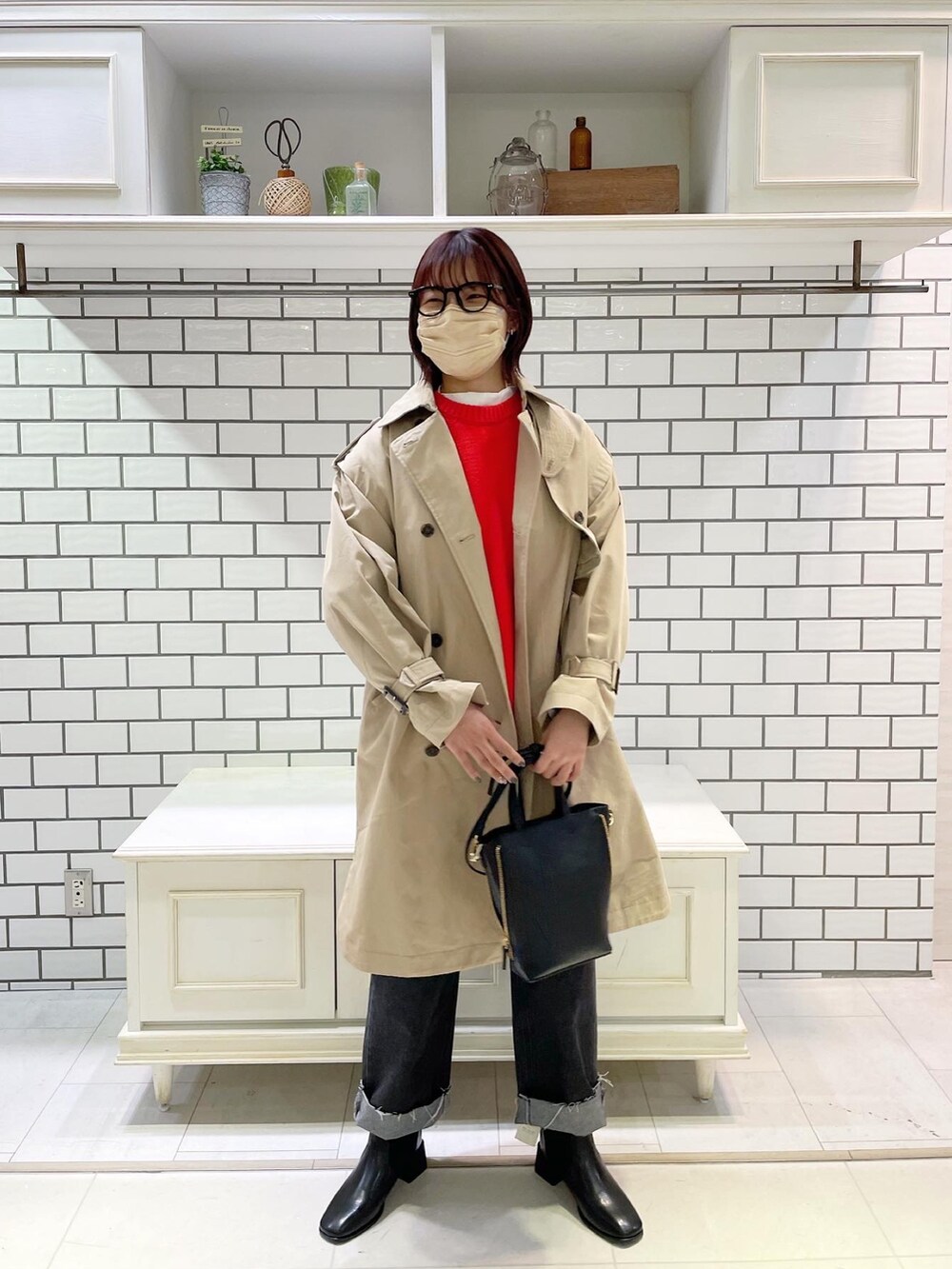 ブラック系のデニムパンツ、ホワイト系のTシャツ/カットソー、オレンジ系のカーディガン/ボレロを着用したレディースの冬コーディネートの2枚目の写真