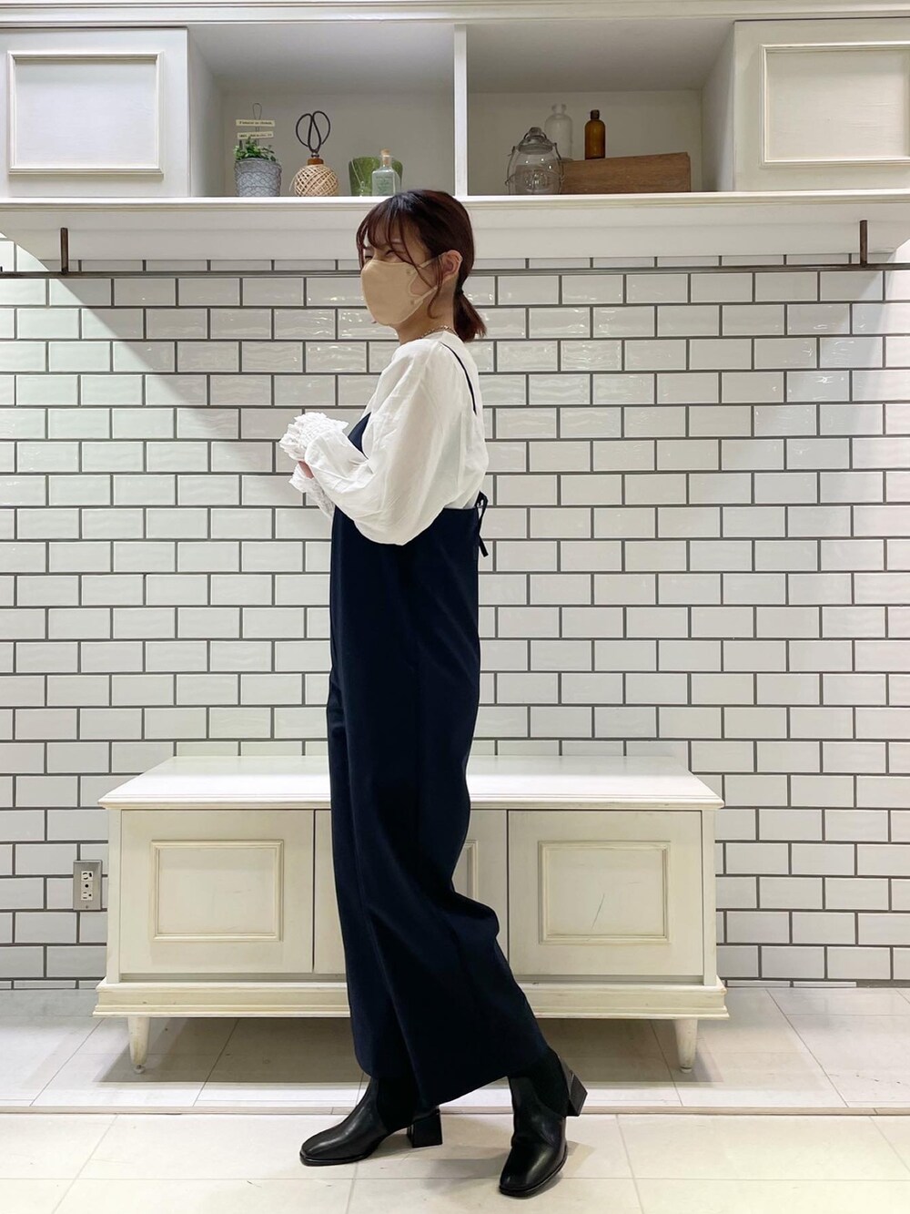 ホワイト系のシャツ/ブラウス、ブルー系のサロペット/オーバーオール、ベージュ系のステンカラーコートを着用したレディースの冬コーディネートの2枚目の写真