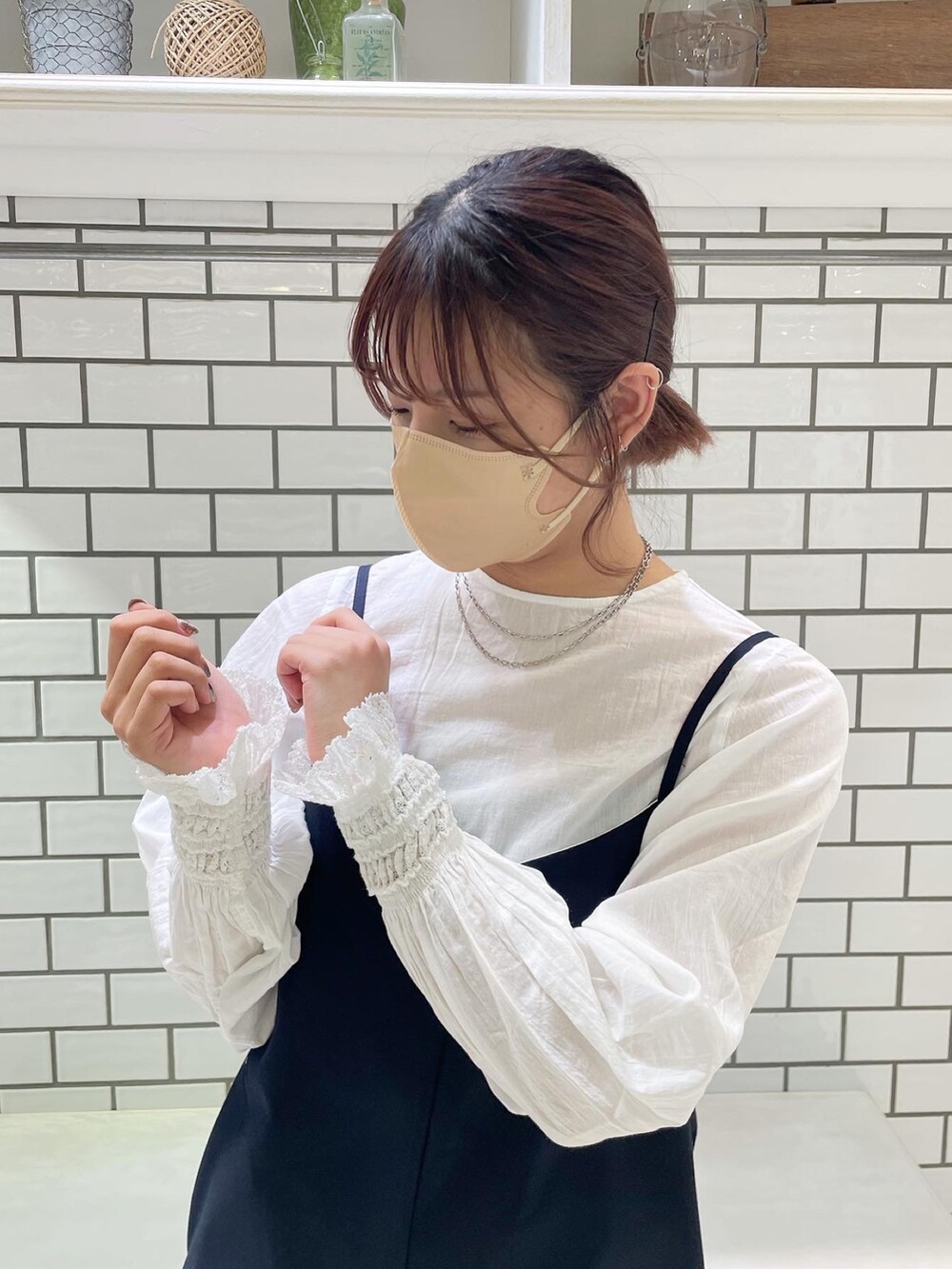 ホワイト系のシャツ/ブラウス、ブルー系のサロペット/オーバーオール、ベージュ系のステンカラーコートを着用したレディースの冬コーディネートの4枚目の写真