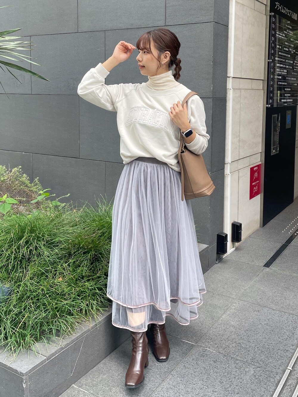 ベージュ系のTシャツ/カットソー、ホワイト系のTシャツ/カットソー、グレー系のスカートを着用したレディースの秋コーディネートの2枚目の写真