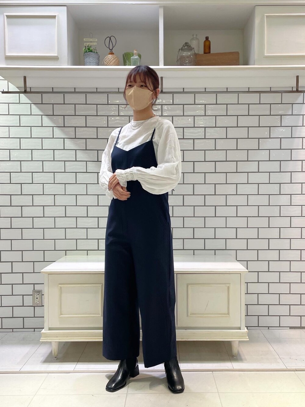 ホワイト系のシャツ/ブラウス、ブルー系のサロペット/オーバーオール、ベージュ系のステンカラーコートを着用したレディースの冬コーディネートの3枚目の写真