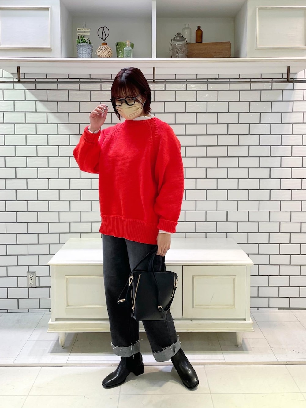 ブラック系のデニムパンツ、ホワイト系のTシャツ/カットソー、オレンジ系のカーディガン/ボレロを着用したレディースの冬コーディネートの3枚目の写真