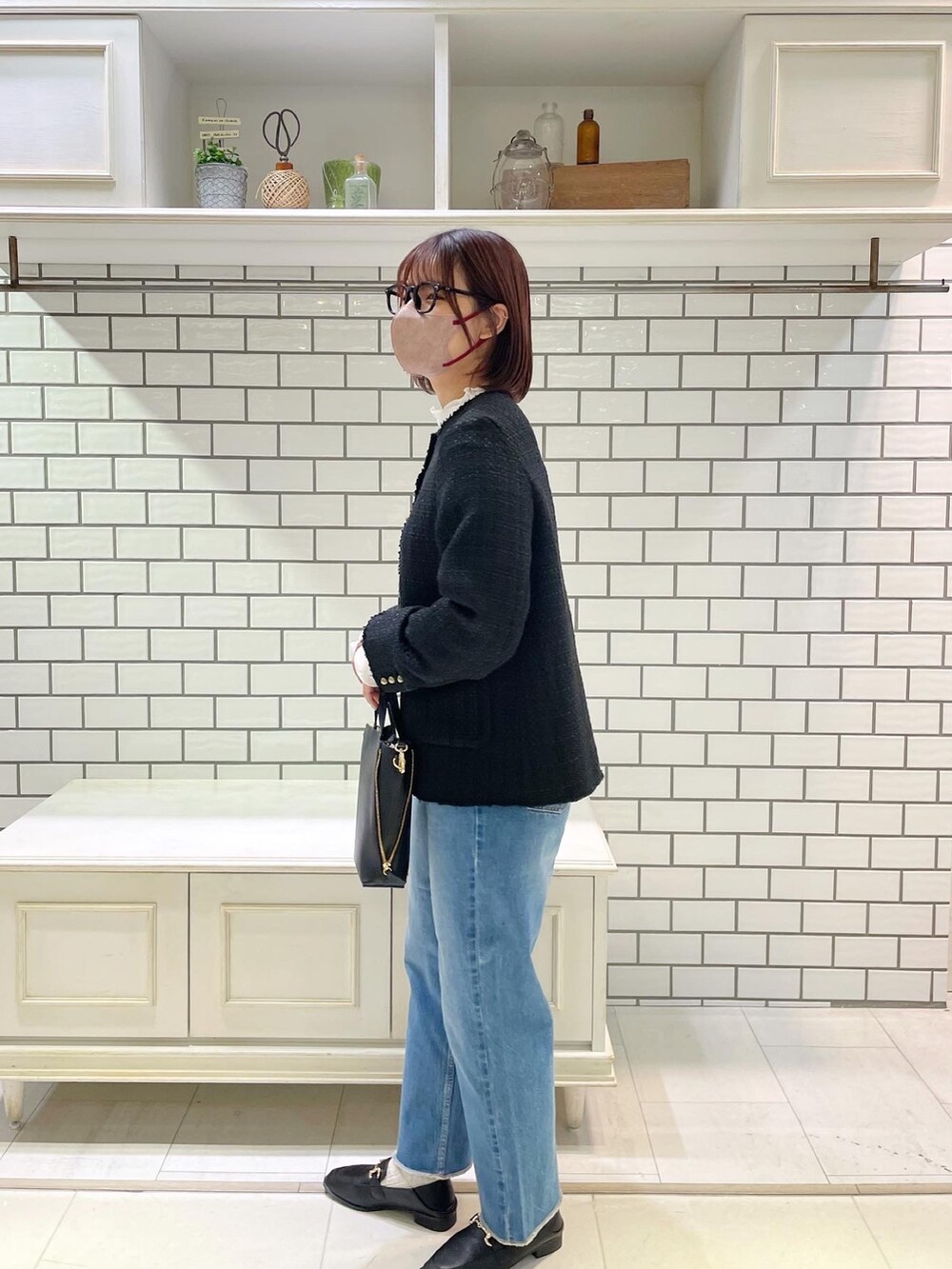 ブラック系のショルダーバッグ、ブラック系のデニムパンツ、ブラック系のその他シューズを着用したレディースの冬コーディネートの2枚目の写真