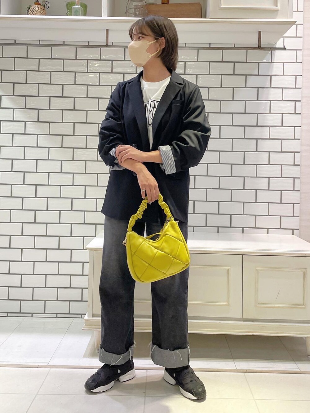 ホワイト系のTシャツ/カットソー、ブラック系のテーラードジャケット、ブラック系のデニムパンツを着用したレディースの秋コーディネートの2枚目の写真