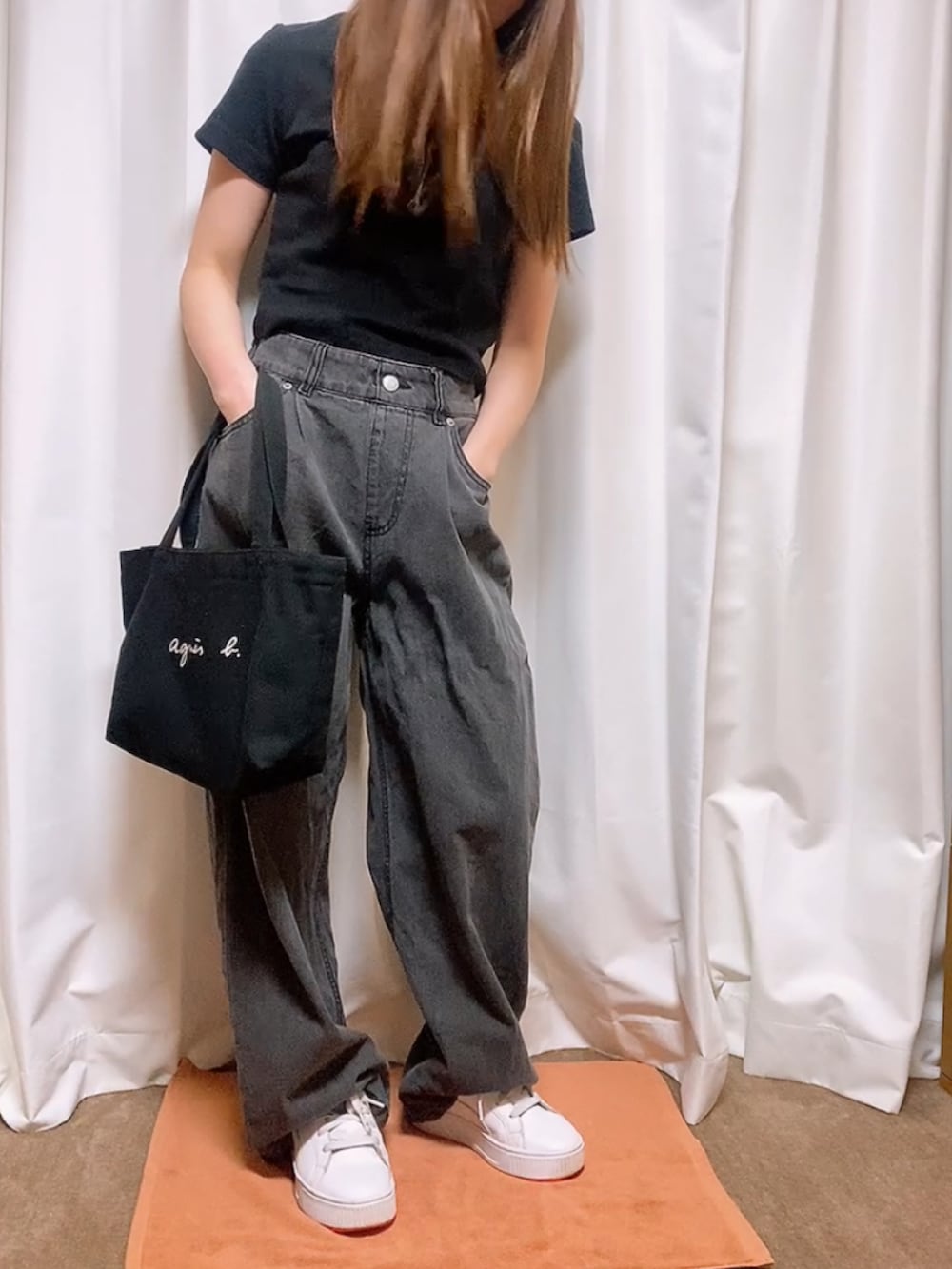 ブラック系のデニムパンツ、ブラック系のTシャツ/カットソー、ブラック系のハンドバッグを着用したレディースの春コーディネートの2枚目の写真