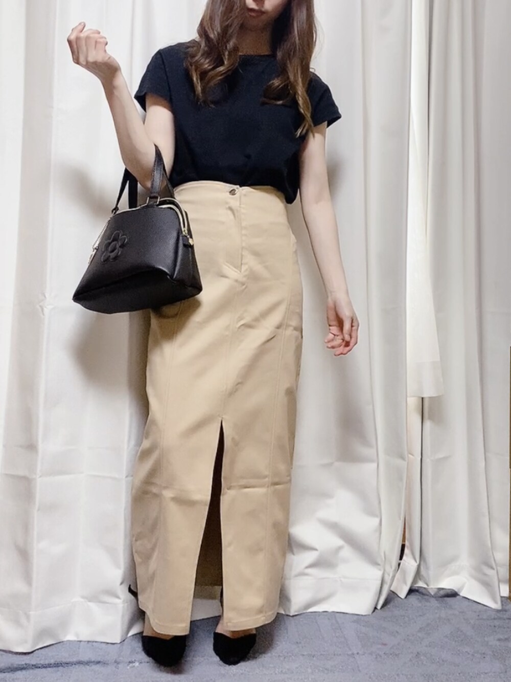 ブラック系のTシャツ/カットソー、ブラック系のハンドバッグ、ベージュ系のスカートを着用したレディースの夏コーディネートの3枚目の写真