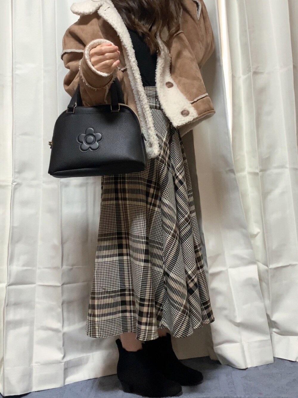 ブラック系のバッグを着用したレディースの冬コーディネートの2枚目の写真