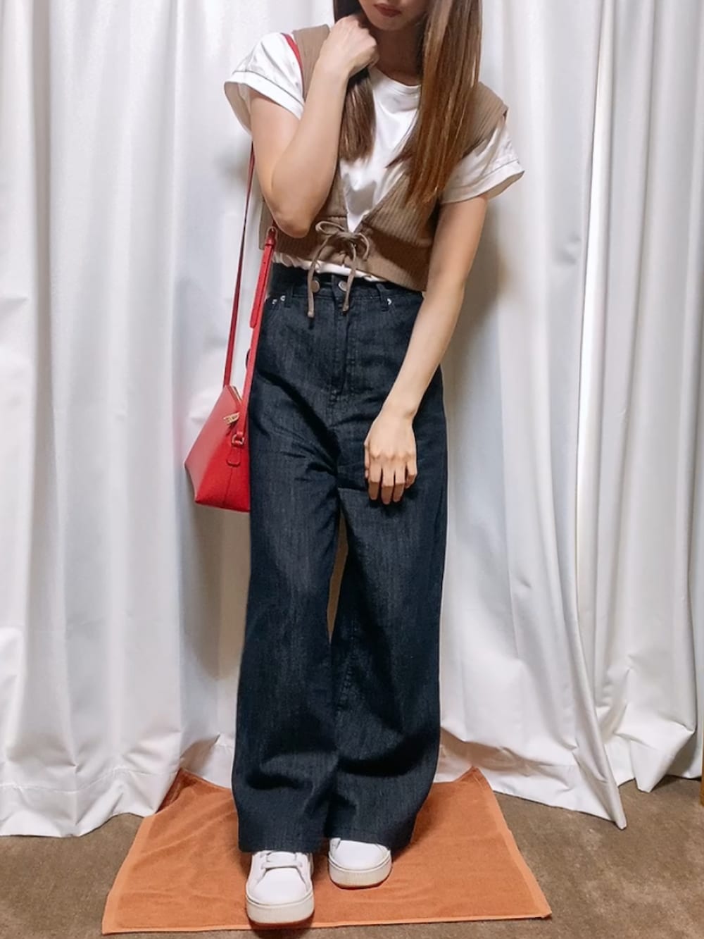 ブラウン系のその他トップス、ブルー系のデニムパンツ、レッド系のショルダーバッグを着用したレディースの秋コーディネートの2枚目の写真