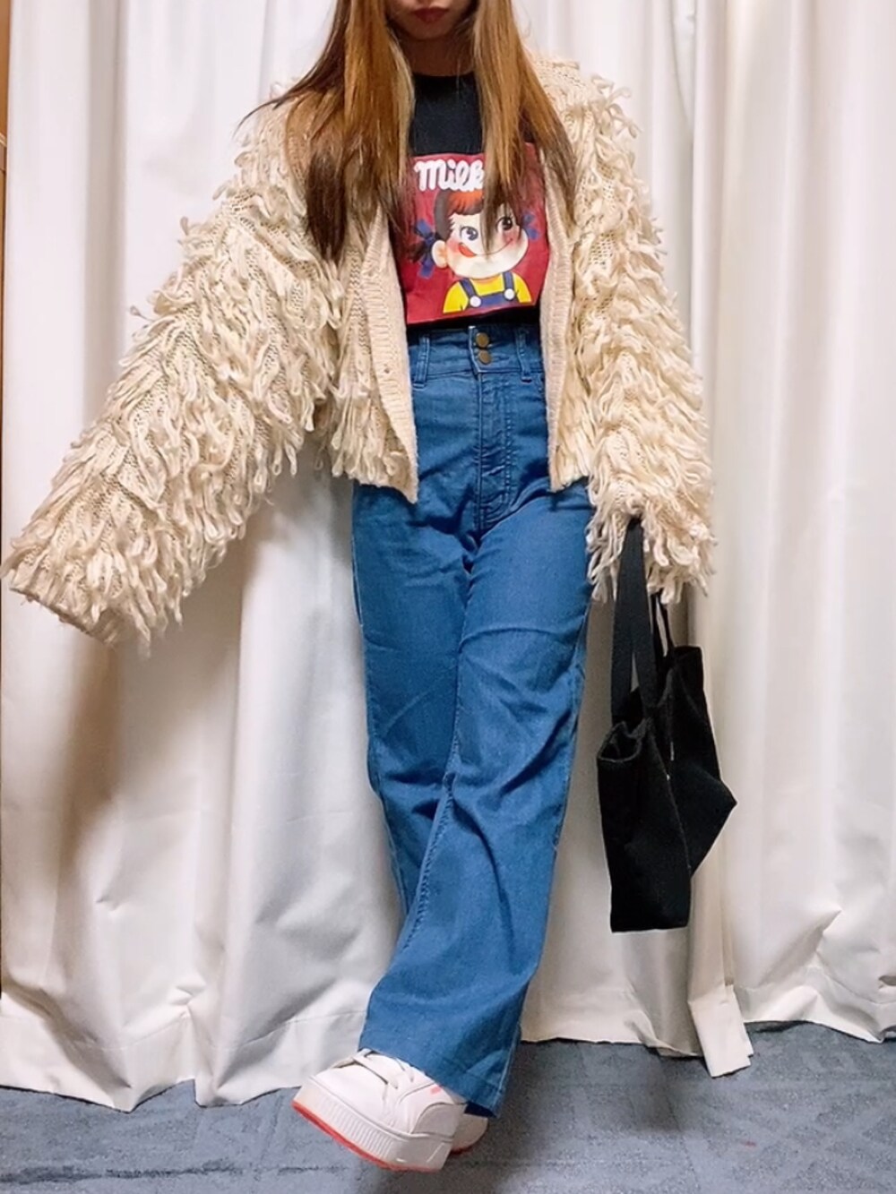 ブラック系のTシャツ/カットソー、ホワイト系のカーディガン/ボレロ、ブラック系のトートバッグを着用したレディースの春コーディネートの2枚目の写真