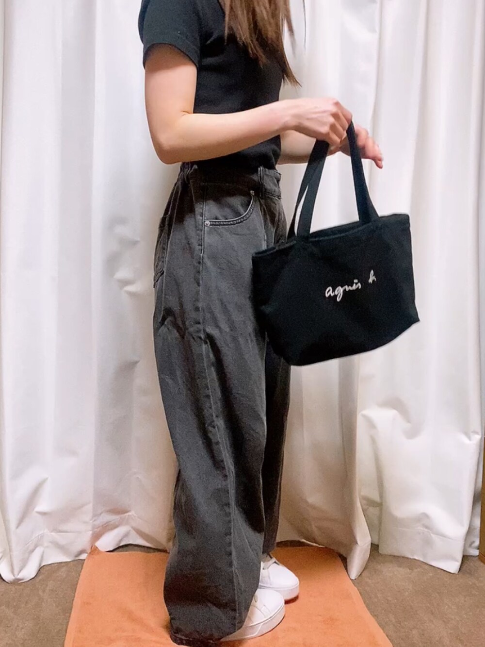 ブラック系のデニムパンツ、ブラック系のTシャツ/カットソー、ブラック系のハンドバッグを着用したレディースの春コーディネートの3枚目の写真