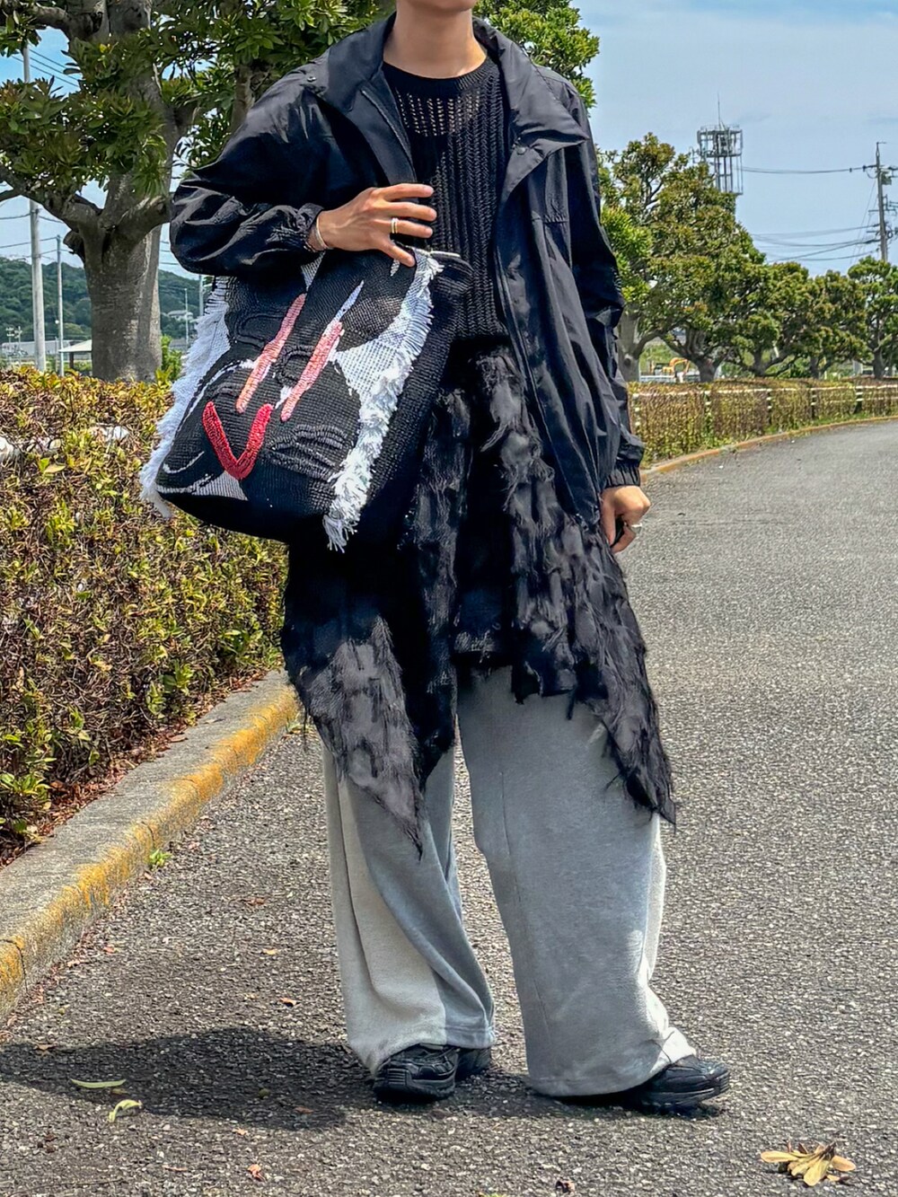 ブラック系のナイロンジャケット、ブラック系のベスト、ブラック系のハンドバッグを着用したメンズの夏コーディネートの2枚目の写真