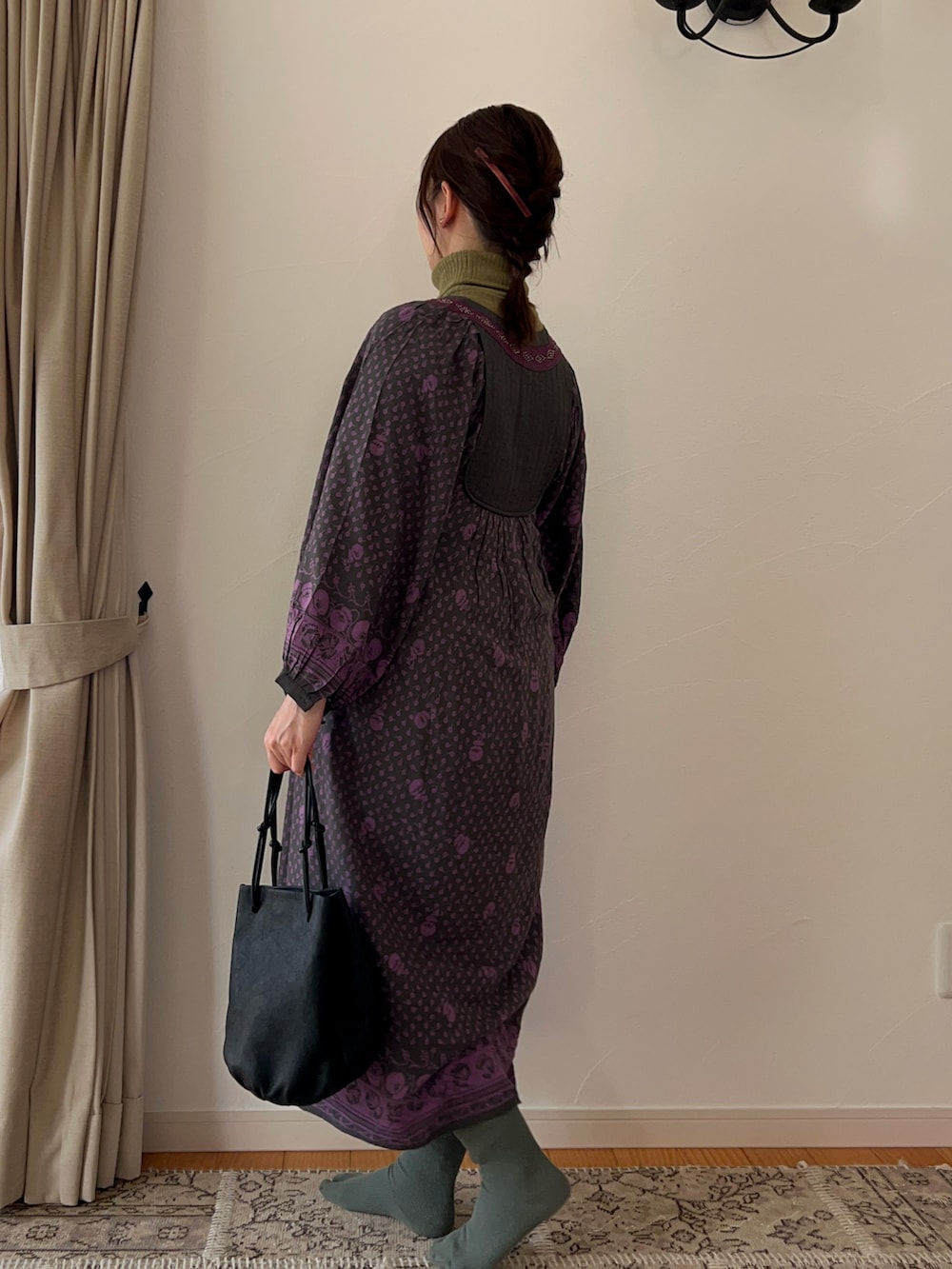 ピンク系のワンピース、ブラック系のハンドバッグを着用したレディースの冬コーディネートの2枚目の写真