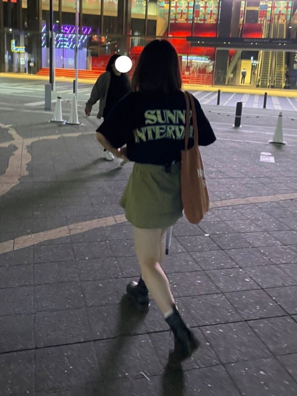 ブラック系のTシャツ/カットソー、ブラック系のブーツ、ブラウン系のトートバッグを着用したレディースの夏コーディネートの2枚目の写真