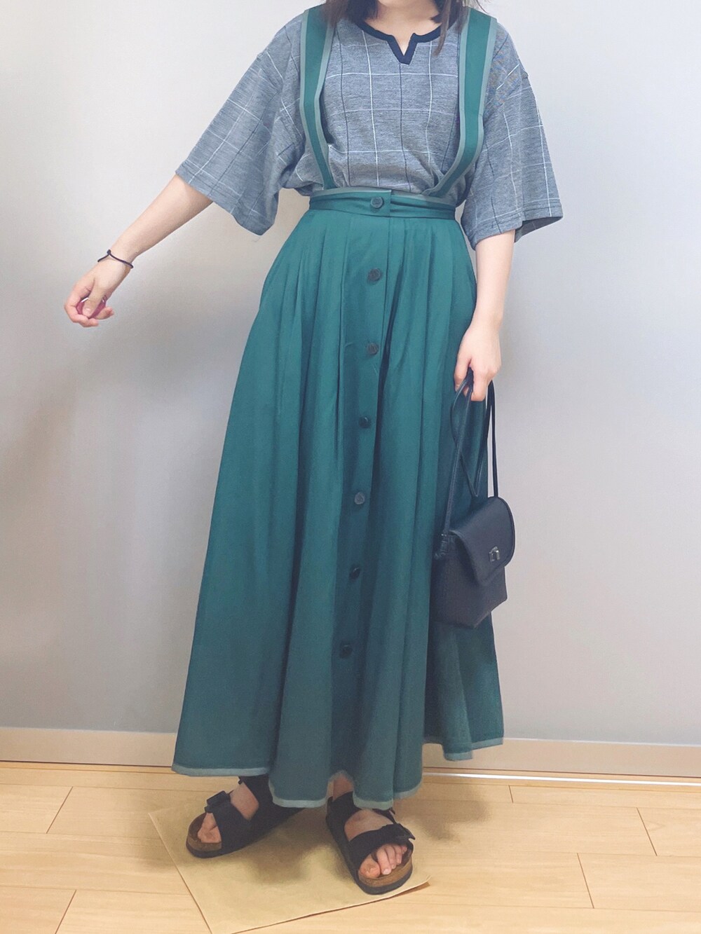 グレー系のTシャツ/カットソー、グリーン系のスカート、ブラック系のショルダーバッグを着用したレディースの秋コーディネートの2枚目の写真