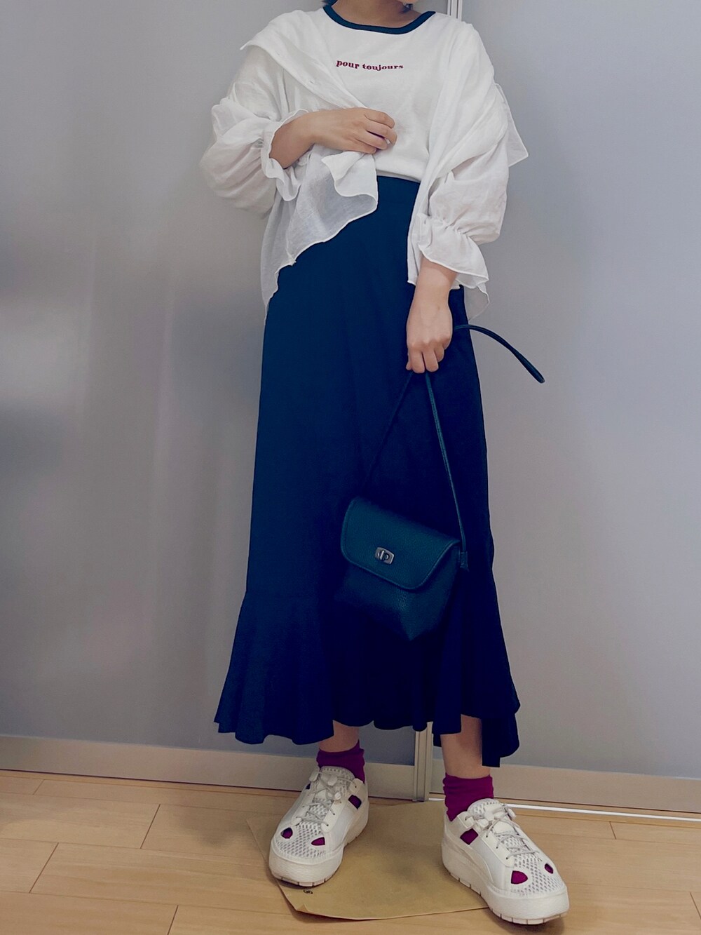 ホワイト系のTシャツ/カットソー、ブラック系のスカート、ブラック系のショルダーバッグを着用したレディースの秋コーディネートの2枚目の写真