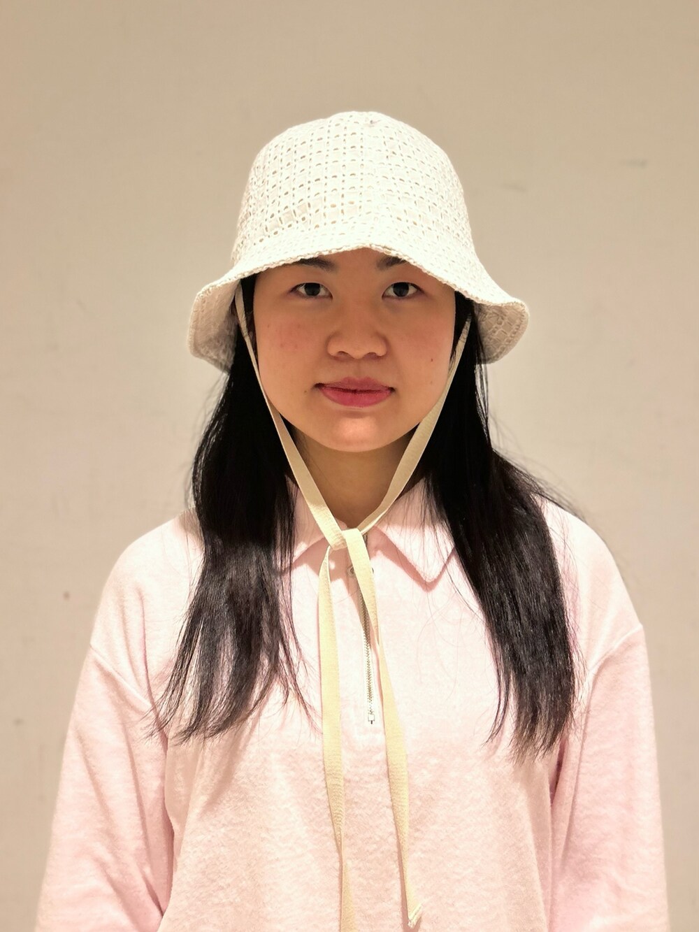 ピンク系のスウェット、ブルー系のデニムパンツ、ホワイト系のスニーカーを着用したレディースの春コーディネートの2枚目の写真