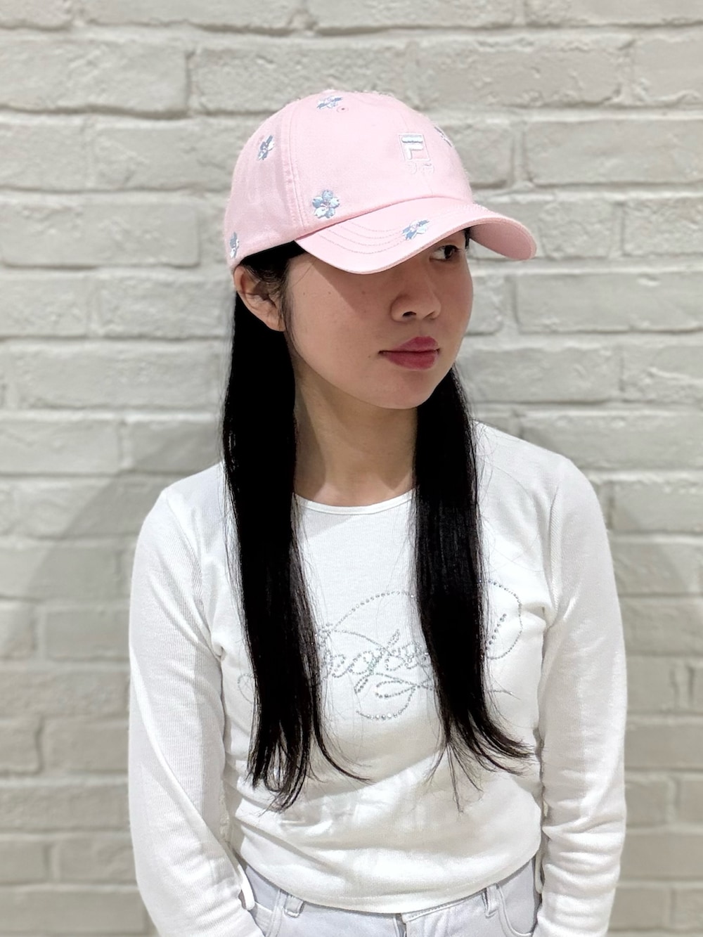 ホワイト系のTシャツ/カットソー、グレー系のデニムパンツ、ホワイト系のスニーカーを着用したレディースの春コーディネートの6枚目の写真