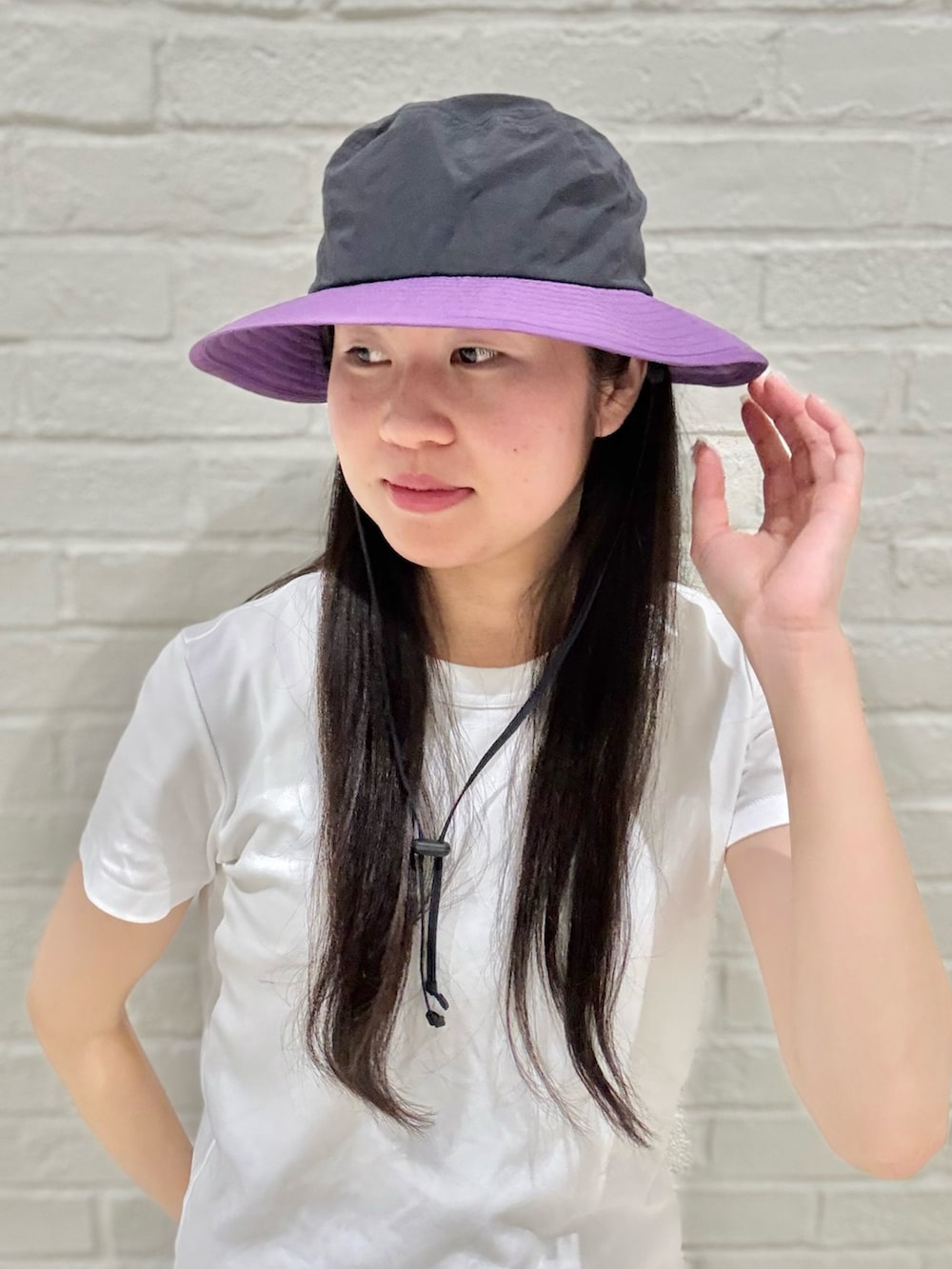 ホワイト系のTシャツ/カットソー、グレー系のその他パンツ、ブラック系のハットを着用したレディースの夏コーディネートの2枚目の写真