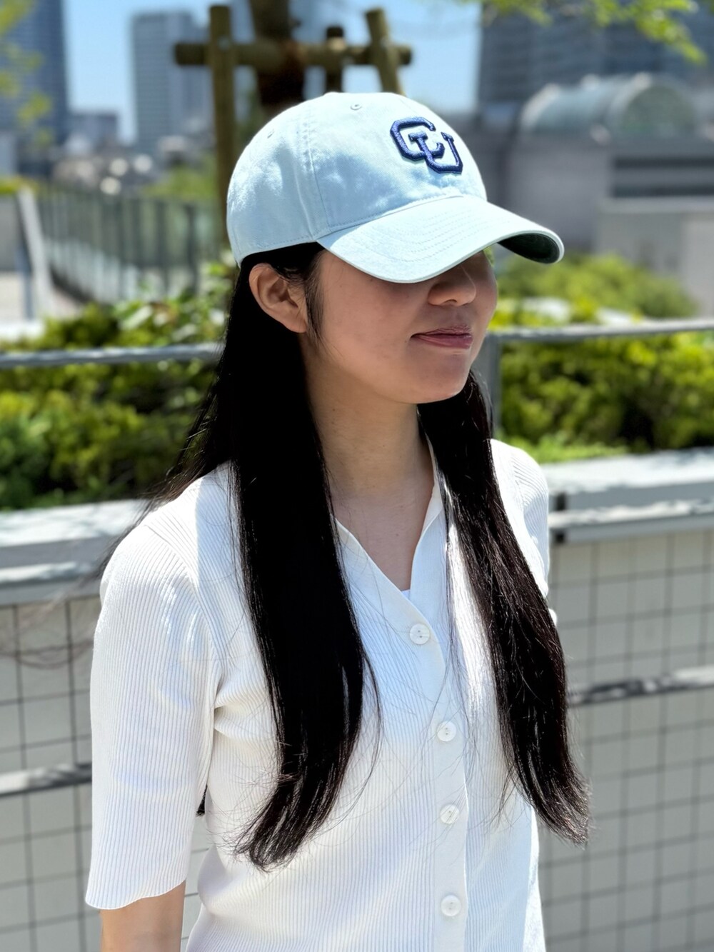 ホワイト系のニット/セーター、グレー系のスラックス、グレー系のスニーカーを着用したレディースの夏コーディネートの5枚目の写真