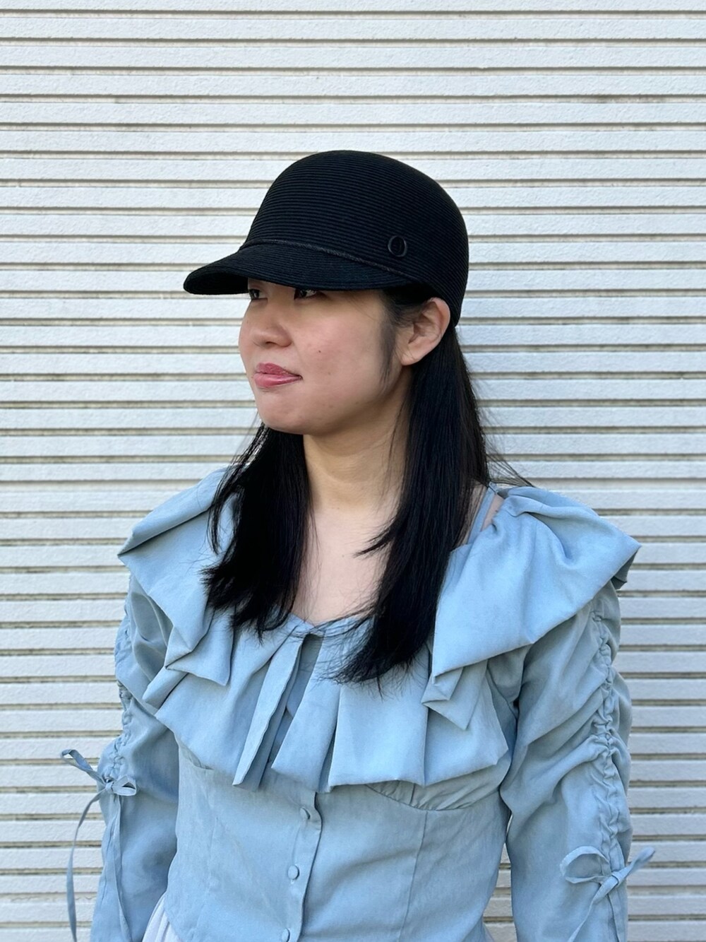 ブルー系のシャツ/ブラウス、グレー系のスカート、ホワイト系のバレエシューズを着用したレディースの春コーディネートの2枚目の写真