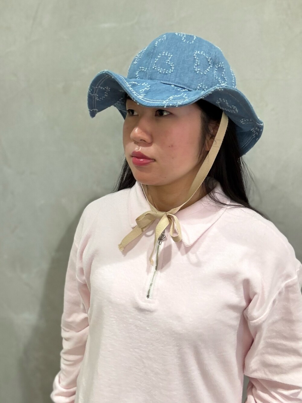 ピンク系のスウェット、ブルー系のデニムパンツ、グレー系のスニーカーを着用したレディースの春コーディネートの4枚目の写真