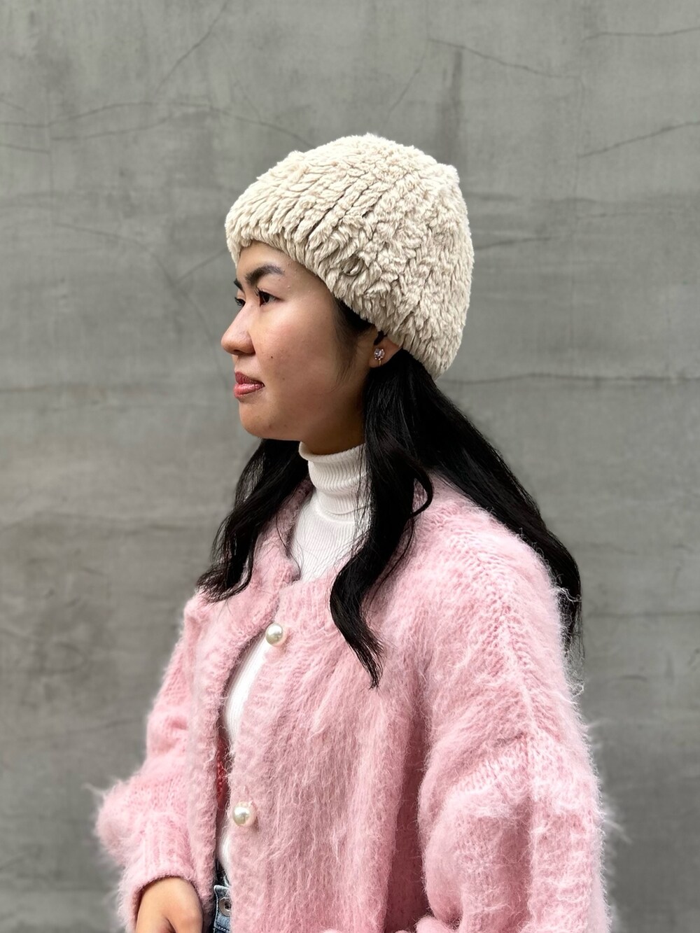 ピンク系のカーディガン/ボレロ、ブルー系のデニムパンツ、ピンク系のブーツを着用したレディースの冬コーディネートの2枚目の写真