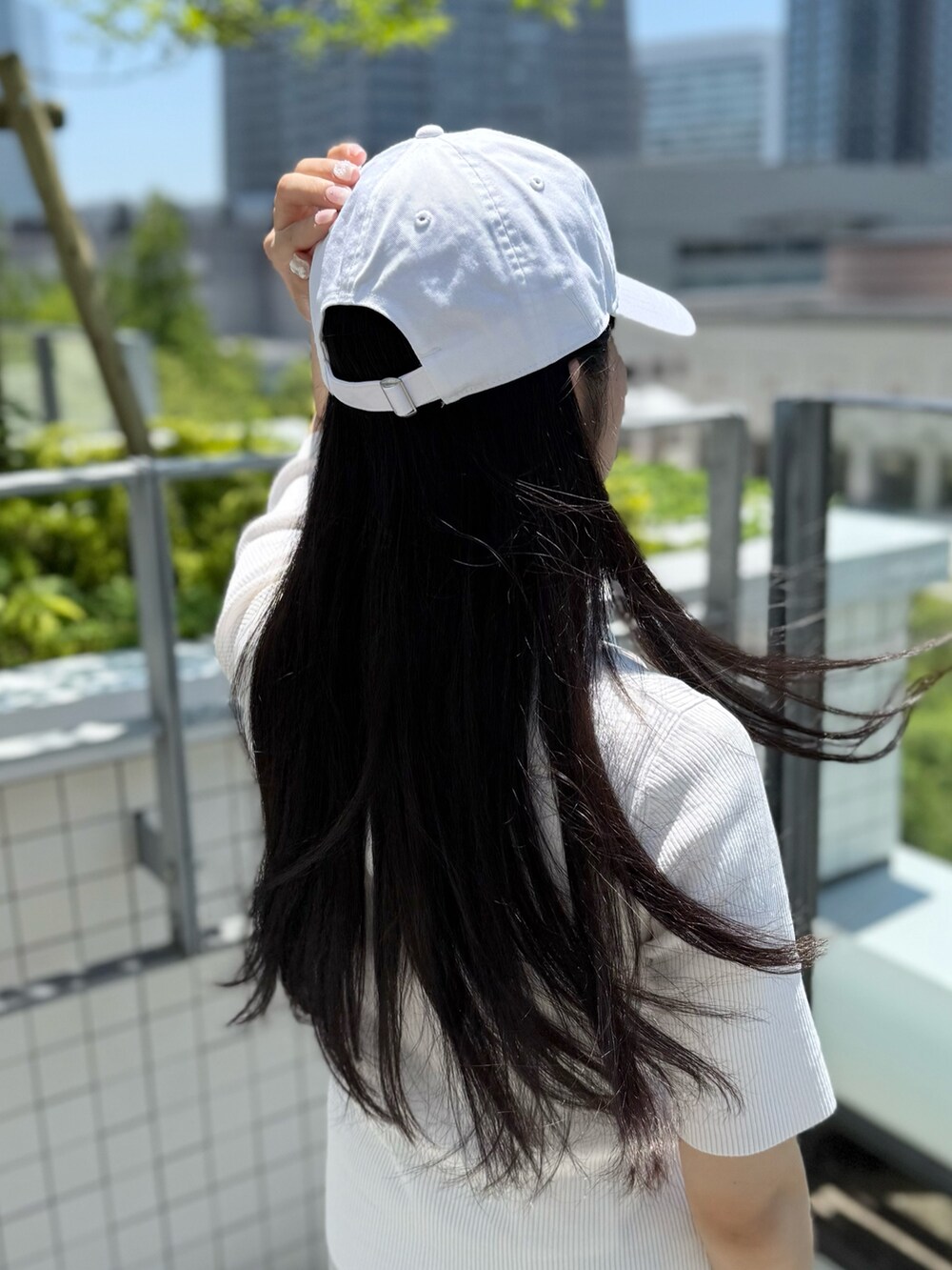 ホワイト系のニット/セーター、グレー系のスラックス、グレー系のスニーカーを着用したレディースの夏コーディネートの3枚目の写真