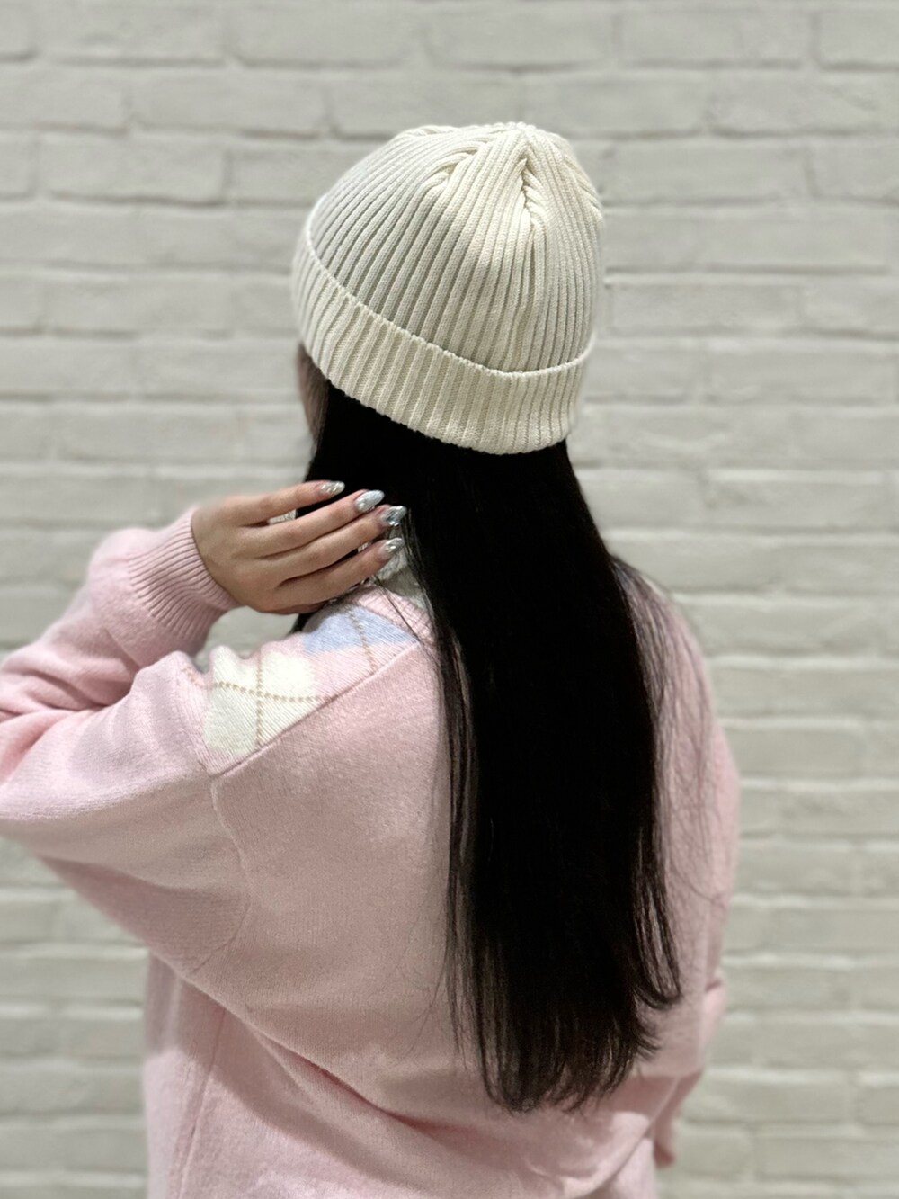 ホワイト系のニット/セーター、ピンク系のニット/セーター、ブルー系のデニムパンツを着用したレディースの冬コーディネートの3枚目の写真