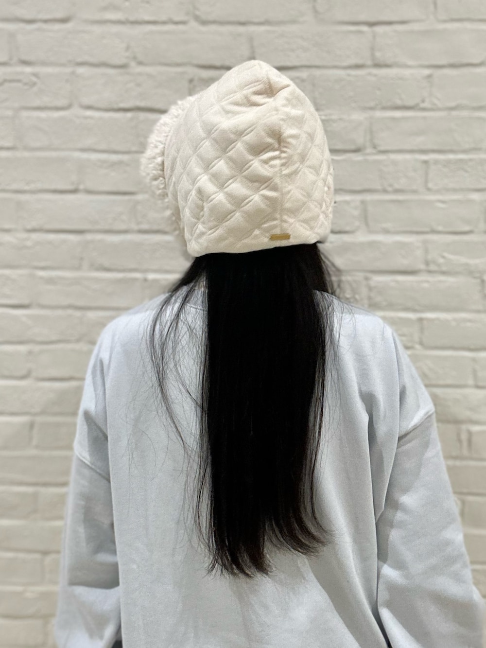 ブルー系のTシャツ/カットソー、ホワイト系のスカート、ホワイト系のスニーカーを着用したレディースの冬コーディネートの4枚目の写真