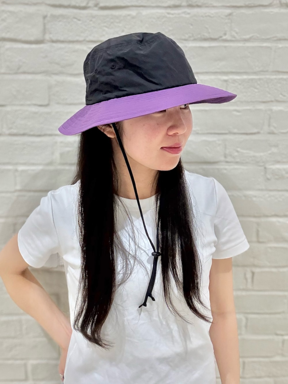 ホワイト系のTシャツ/カットソー、グレー系のその他パンツ、ブラック系のハットを着用したレディースの夏コーディネートの5枚目の写真