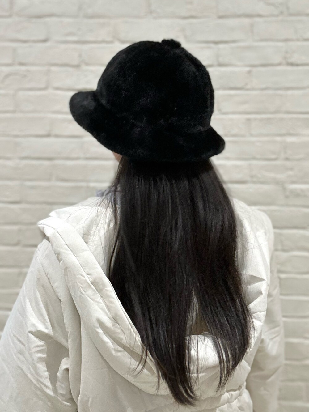 ホワイト系のダウンジャケット/コート、グレー系のニット/セーター、ブルー系のスウェットを着用したレディースの冬コーディネートの5枚目の写真