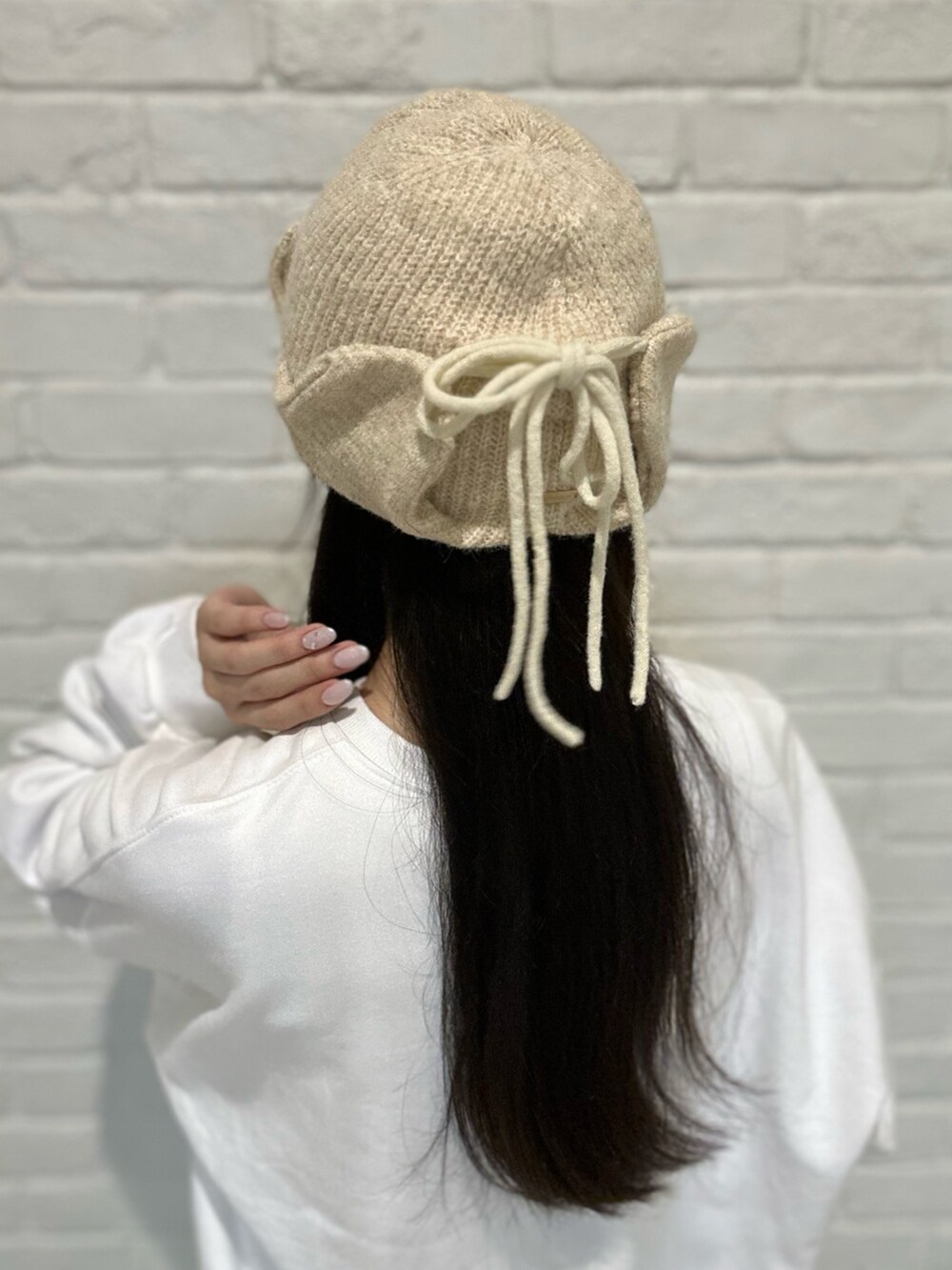 ホワイト系のスウェット、ピンク系のスニーカー、ブルー系のパンツを着用したレディースの秋コーディネートの7枚目の写真