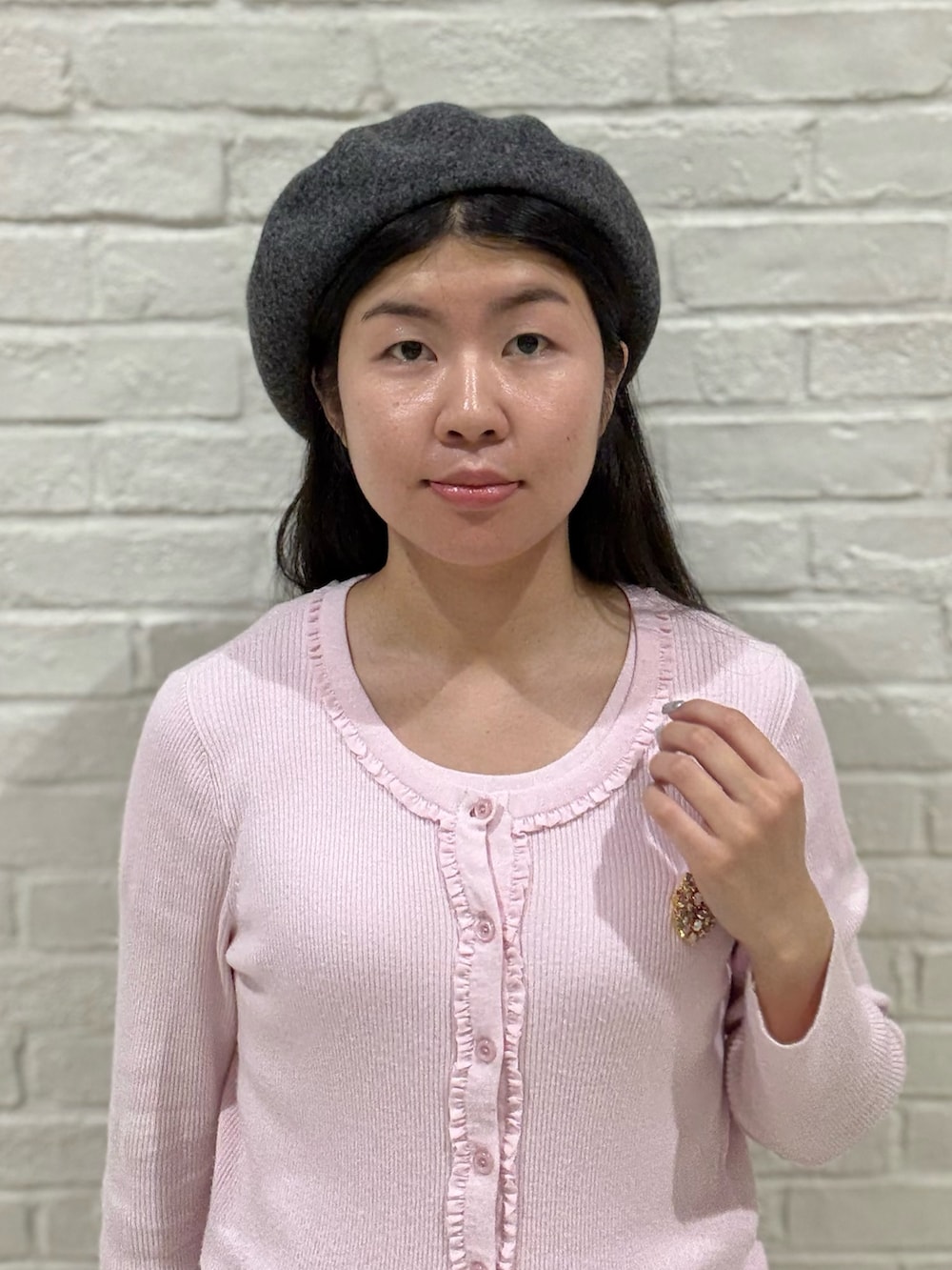 ピンク系のTシャツ/カットソー、ピンク系のカーディガン/ボレロ、グレー系のスカートを着用したレディースの秋コーディネートの2枚目の写真