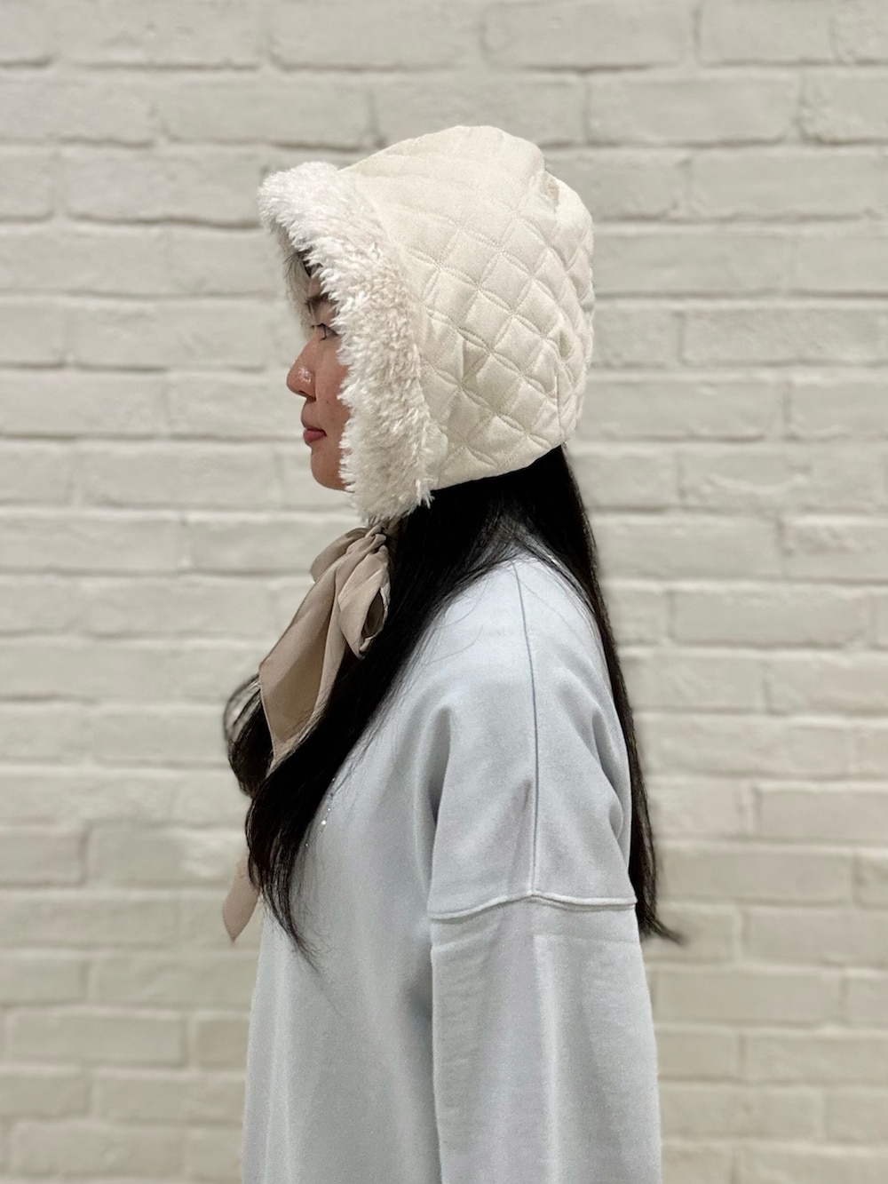 ブルー系のTシャツ/カットソー、ホワイト系のスカート、ホワイト系のスニーカーを着用したレディースの冬コーディネートの3枚目の写真