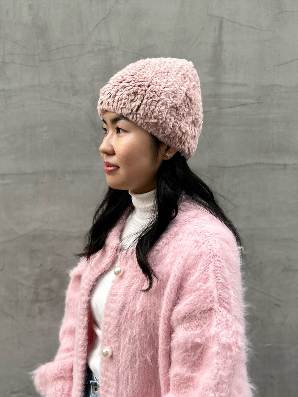 ピンク系のカーディガン/ボレロ、ブルー系のデニムパンツ、ピンク系のブーツを着用したレディースの冬コーディネートの8枚目の写真