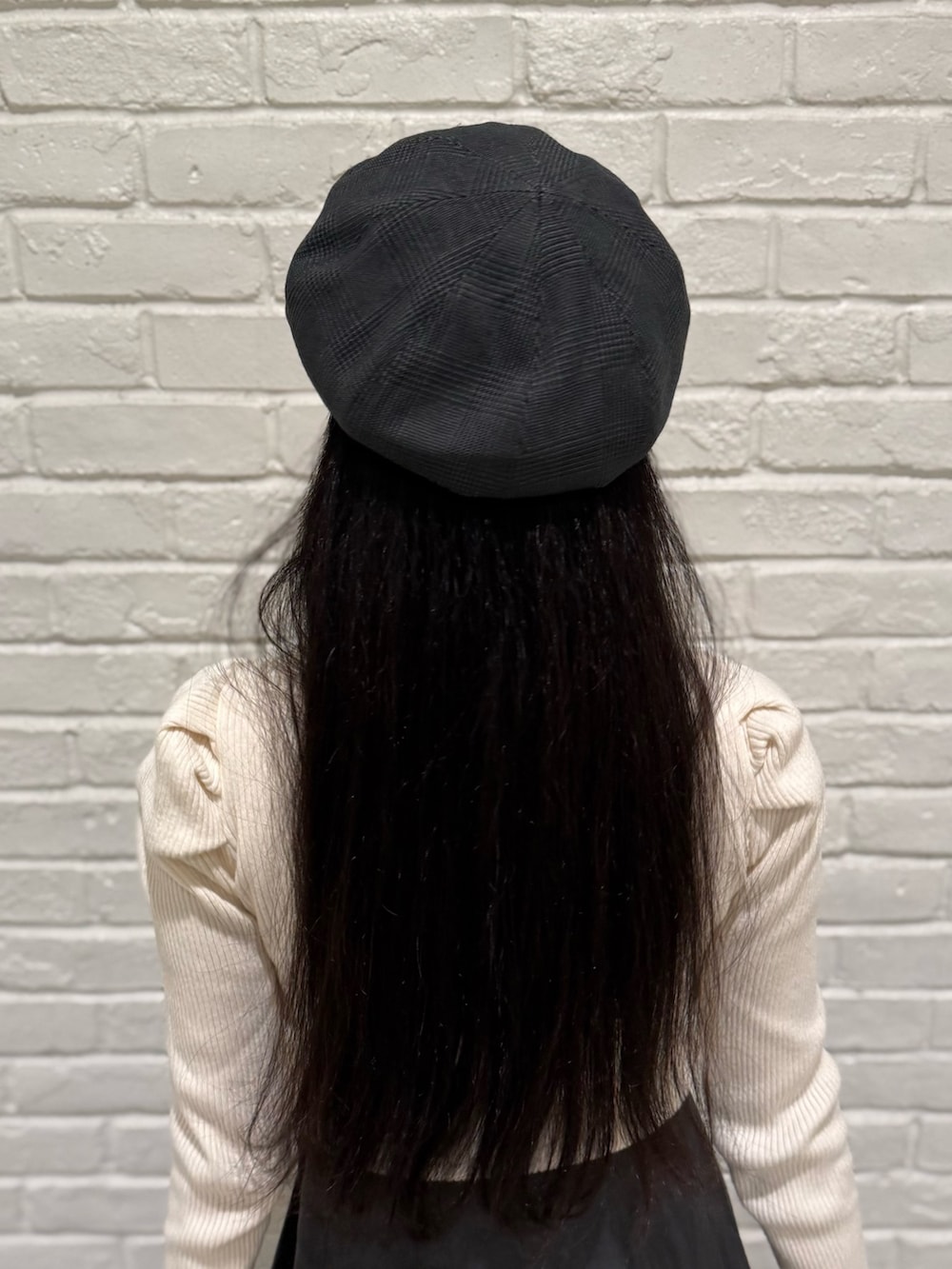 ベージュ系のニット/セーター、グレー系のスカート、ブラック系のブーツを着用したレディースの冬コーディネートの4枚目の写真