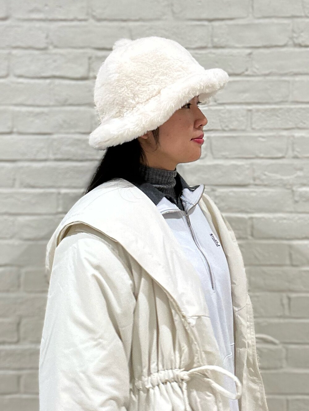 ホワイト系のダウンジャケット/コート、グレー系のニット/セーター、ブルー系のスウェットを着用したレディースの冬コーディネートの3枚目の写真