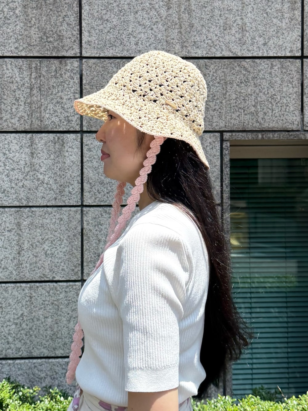 ホワイト系のニット/セーター、ピンク系のスカート、ホワイト系のシューズを着用したレディースの夏コーディネートの4枚目の写真