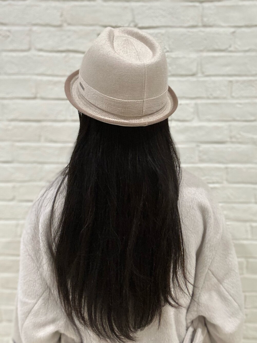 グレー系のニット/セーター、ベージュ系のステンカラーコート、ブラック系のスニーカーを着用したレディースの冬コーディネートの3枚目の写真