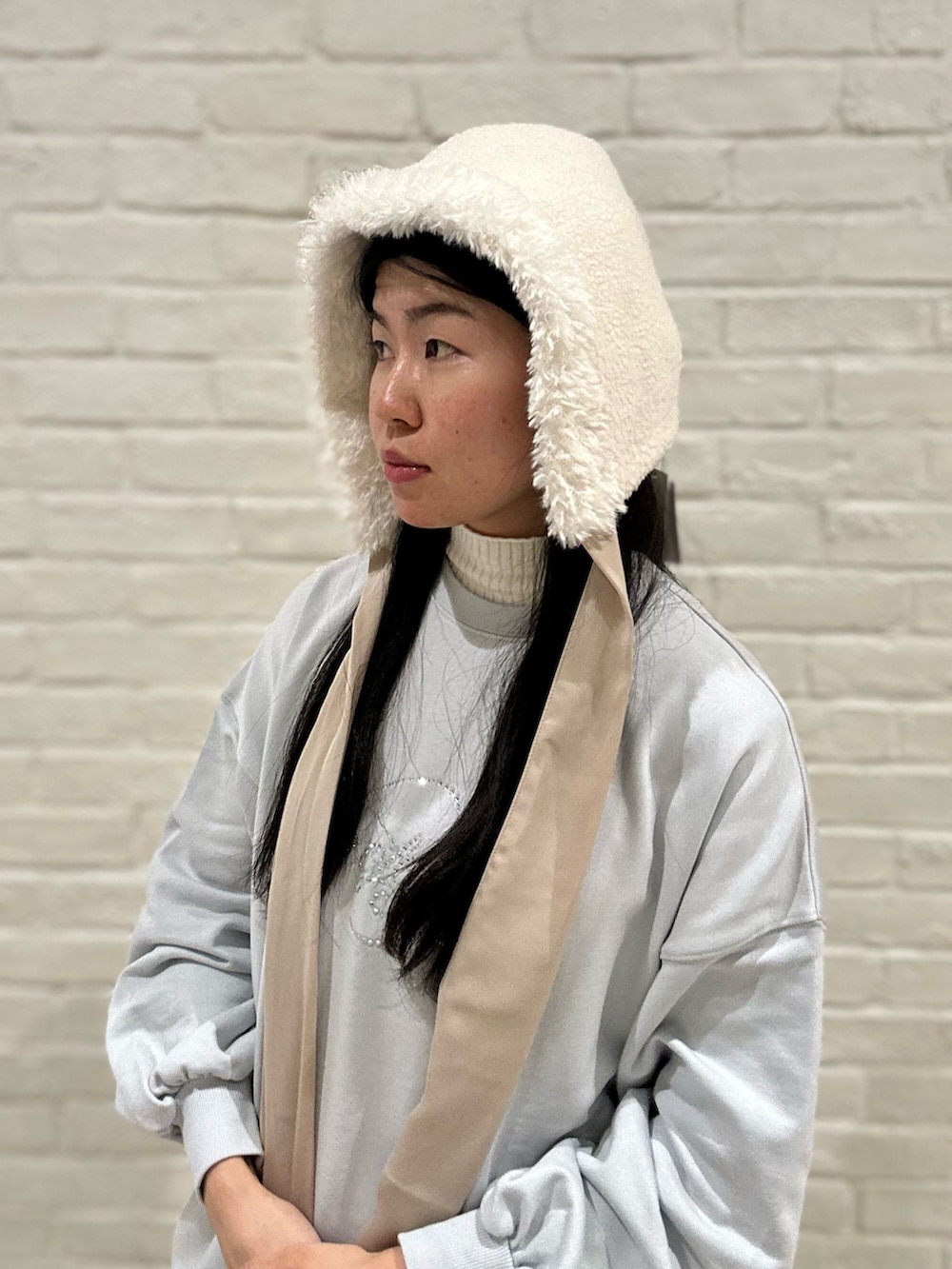 ブルー系のTシャツ/カットソー、ホワイト系のスカート、ホワイト系のスニーカーを着用したレディースの冬コーディネートの6枚目の写真