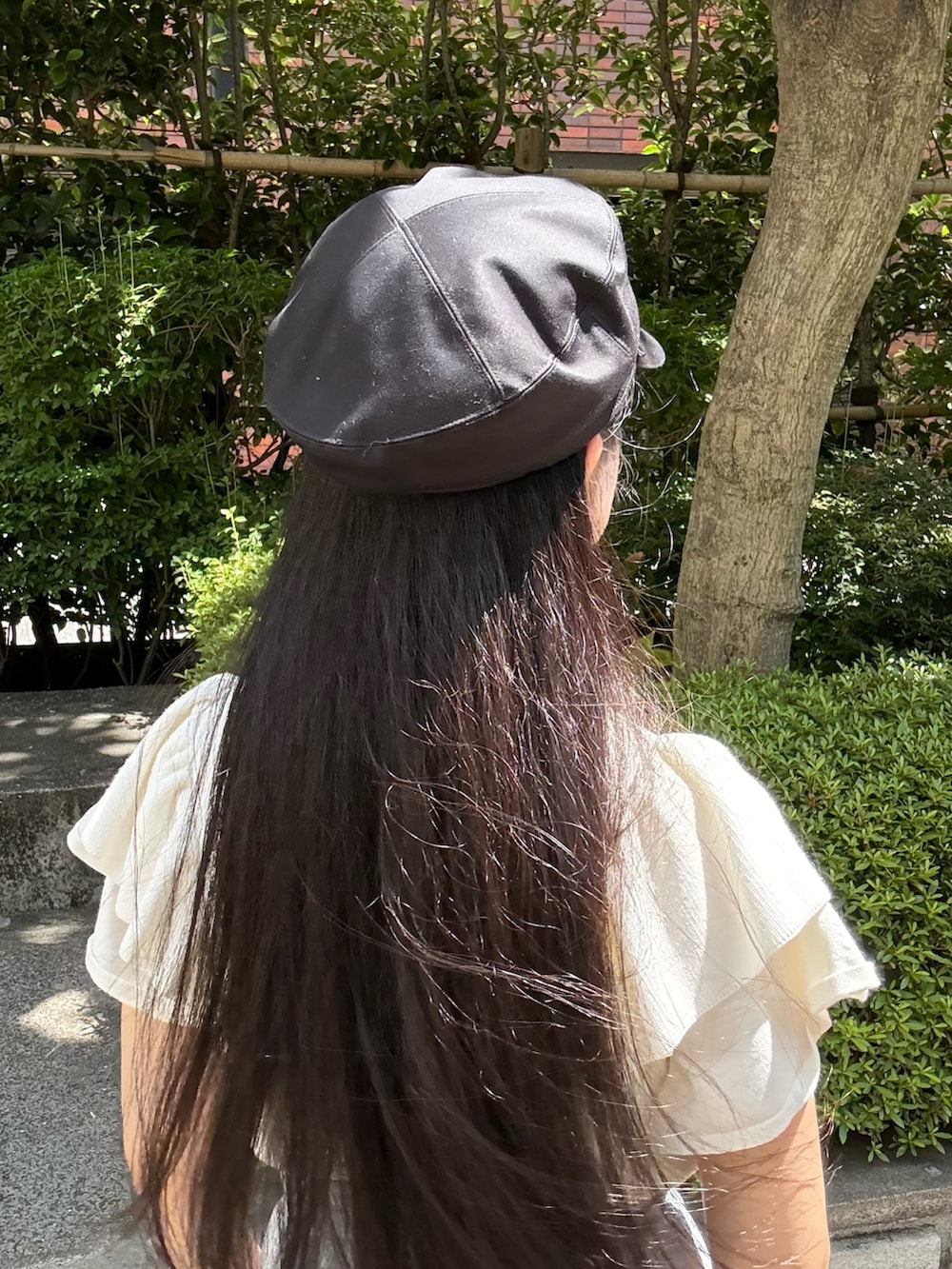 ホワイト系のニット/セーター、グレー系のスカート、ベージュ系のスニーカーを着用したレディースの夏コーディネートの4枚目の写真