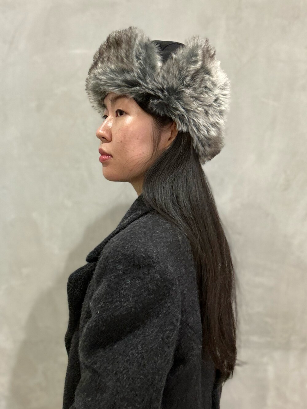 グレー系のジャケット/アウター、グレー系のニット/セーター、パープル系のデニムパンツを着用したレディースの冬コーディネートの2枚目の写真