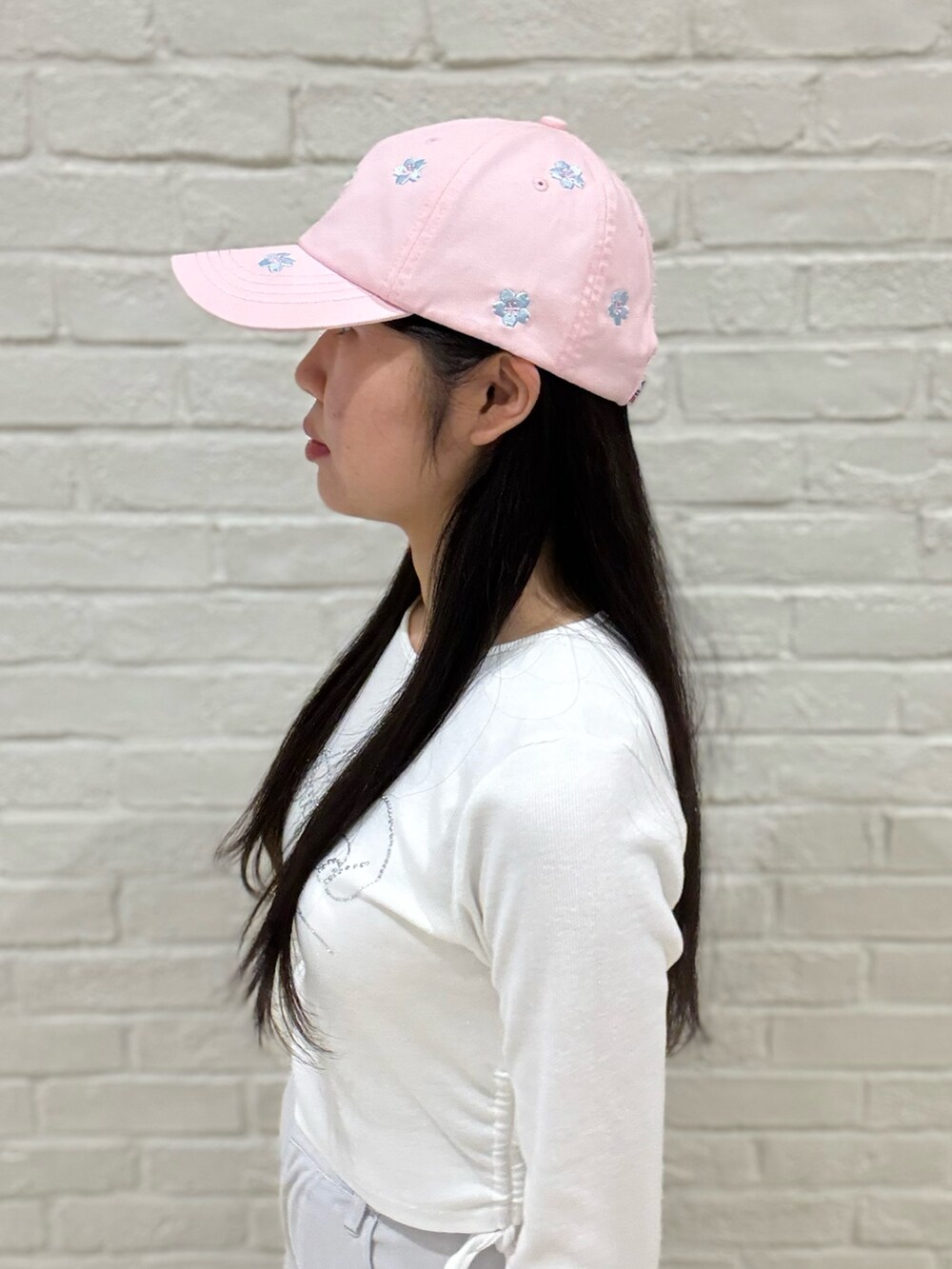 ホワイト系のTシャツ/カットソー、グレー系のデニムパンツ、ホワイト系のスニーカーを着用したレディースの春コーディネートの4枚目の写真