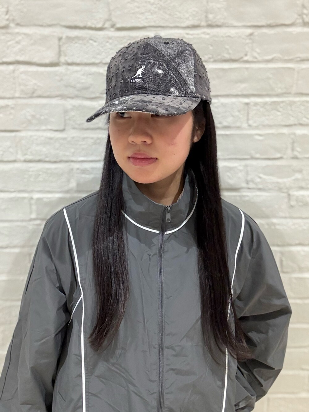 グレー系のマウンテンパーカー、ホワイト系のデニムパンツ、ブラック系のローファーを着用したレディースの夏コーディネートの2枚目の写真