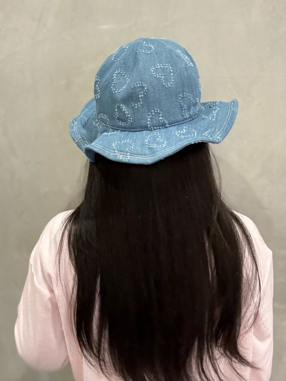 ピンク系のスウェット、ブルー系のデニムパンツ、グレー系のスニーカーを着用したレディースの春コーディネートの5枚目の写真